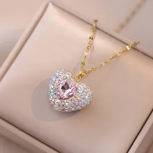 Gouden ketting met roze hart edelsteen en AB-steentjes in een fluwelen sieradendoos