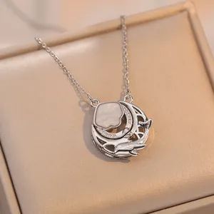 Collier élégant avec pendentif lune, fleur rose et breloque dauphin sur boîte à bijoux