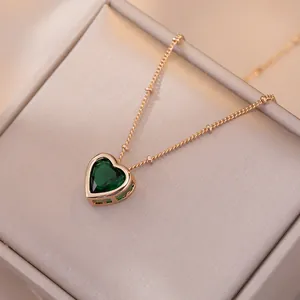 Collier cœur doré élégant avec zircon vert émeraude et perles sur un coffret cadeau