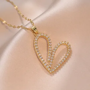 Collana con pendente a cuore dorato con pavé di zirconi su sfondo di seta color champagne