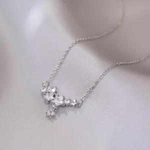 Elegant silver star cluster necklace with zircon pendants on grey silk fabric backdrop