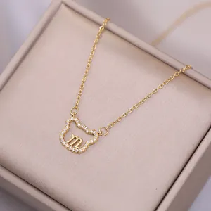 Collier minimaliste en or avec pendentif ours évidé, bordure zircon et lettre M