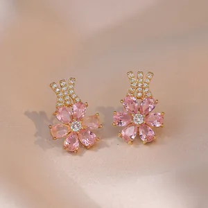 Ohrstecker mit rosa Zirkonia-Blüten und goldener geometrischer Kreuzform mit Kristallen