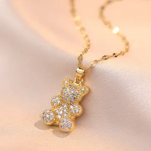 Close-up of golden bear pendant with sparkling zircon micro-pave on silk background