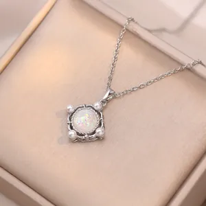 Elegante collar de plata con opalo iridiscente y perlas sobre terciopelo champán