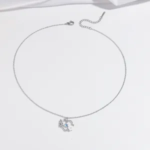 Silver heart necklace with blue moonstone and white floral pendant on a silk background