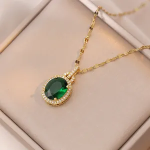 Collier goutte d'or avec pierre verte émeraude et zircons brillants dans un écrin de velours