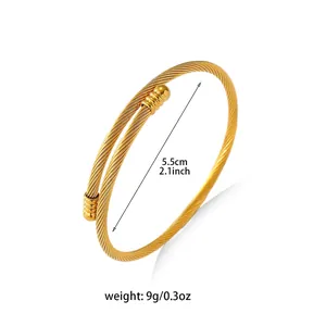 Golden twisted cable bangle with striped end caps for women, diameter 5.5cm and 9g weight