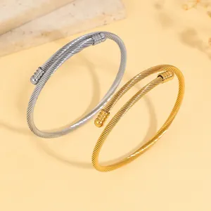 Detailed view of adjustable twisted cable bracelets in gold and silver finishes