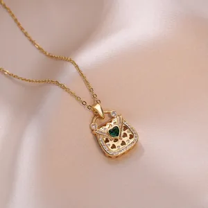 Elegant gold necklace with handbag pendant, heart green gemstone and white crystals