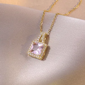 Elegant gold necklace with square pink gemstone pendant on champagne silk background