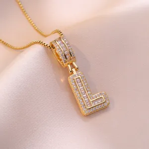 Elegant gold initial L pendant necklace with zircon stones on silk background