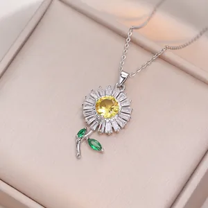 Elegant sunflower pendant necklace with yellow and green crystals in a jewelry box