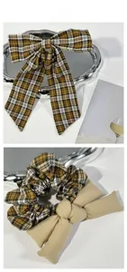 Close-up tile display of plaid bow hair clip and khaki fabric hair scrunchie set