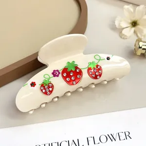 Dettaglio di un grande fermaglio per capelli crema con fragole 3D e strass brillanti