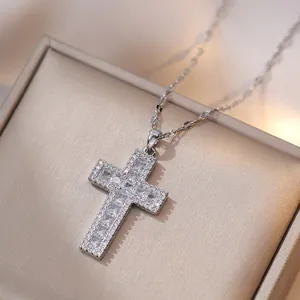 Vue macro d'un pendentif croix en acier inoxydable argenté avec zircons étincelants