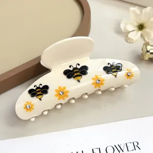Dettaglio della pinza per capelli in acetato con api e piccoli fiori con strass