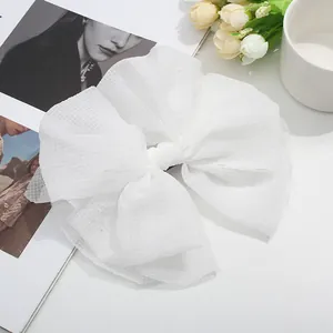 Gros plan d'une grande pince à cheveux nœud en tulle blanc avec texture en maille fine