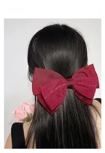 Detailansicht einer weinroten Satin-Haarschleife mit strukturierter Gaze am Modell