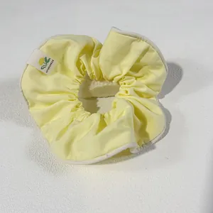 Light yellow candy-colored oversized scrunchie with white piping and happiness tag