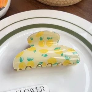 Detailed close-up of a resin hair claw clip with fresh lemon and leaf print on a tray
