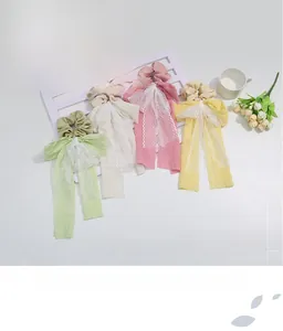 Detailed view of sweet lace ribbon bow hair ties in green, beige, pink and yellow