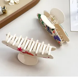 Set di mollette per capelli in acetato con fiori rosa e farfalle su sfondo bianco