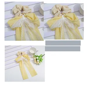Detail of yellow bow scrunchie with lace ribbons and soft crinkled fabric texture