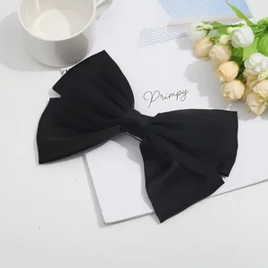 Eleganter großer schwarzer Satin-Haarclip mit Schleife auf minimalistischem Hintergrund