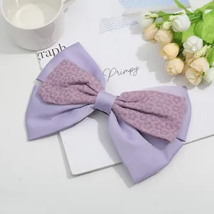 Eleganter lavendelfarbener Haarschmuck aus Seidensatin mit doppelter Schleife und Blumen