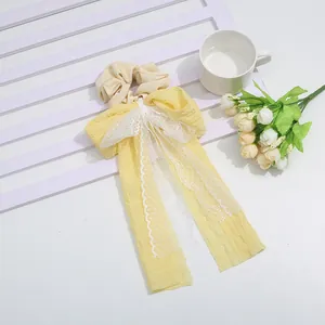 Elegant yellow bow scrunchie with white lace detailing and long ribbon streamers