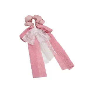Pink ribbon bow scrunchie with white lace details and long flowing fabric streamers