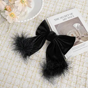 Elegant large black velvet bow hair clip with plush feather trim on a white grid background