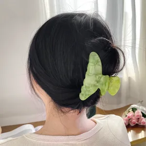 Pince à cheveux papillon vert clair avec texture marbrée pour coiffure élégante