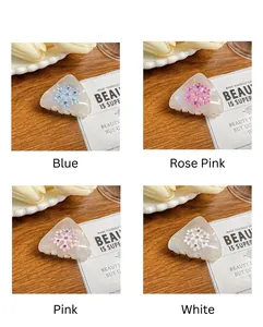 Dettaglio di quattro mollette per capelli a fiocco di neve in blu, rosa, rosa e bianco