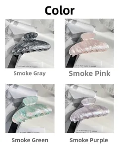 Detail of elegant marble-textured acrylic hair claws in four sophisticated smoky colors