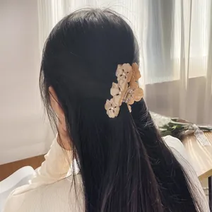 Pince à cheveux trèfle en acétate avec perles sur la chevelure d'une femme