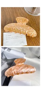 Detail shot of the amber marble texture and polished finish on a large acrylic hair claw