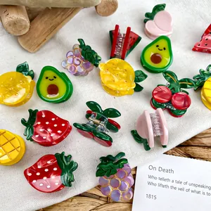Vibrant fruit-shaped acetate hair claws including strawberry and avocado designs