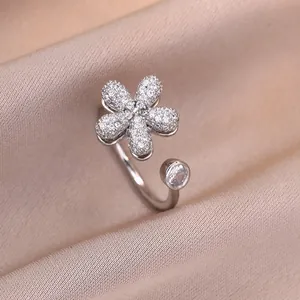 Silver flower ring with pavé diamonds and a round zircon on champagne silk fabric