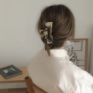Grande pince à cheveux en acétate à motif marbre crème vue de dos sur les cheveux
