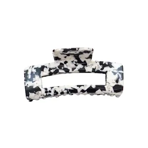 Rectangle acetate hair claw clip with black and white marble pattern on white background