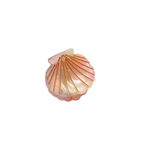 Pink gradient shell hair claw clip with golden stripes and pearlescent acetate finish