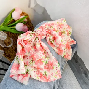 Vista dettagliata dell'accessorio per capelli in chiffon a fiori rosa sul denim