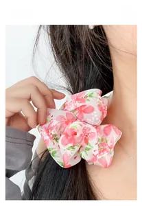 Dettaglio di un elastico per capelli in organza floreale per un look dolce ed estivo
