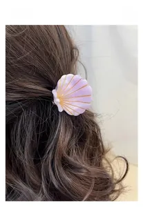 Detailed view of lavender shell hair claw clip with gold lines and white pearl decoration