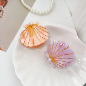 Elegant shell-shaped hair claw clips with pearly finish and white pearl accents