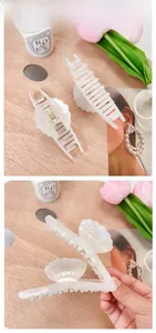 Dettaglio di pinze per capelli a conchiglia in bianco perla iridescente lucido