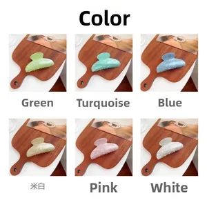 Detalle de pinzas de acrílico en verde, cian, azul, blanco roto, rosa y mármol blanco