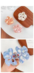 Detail of colorful floral hair claws with iridescent finish and metal spring mechanism